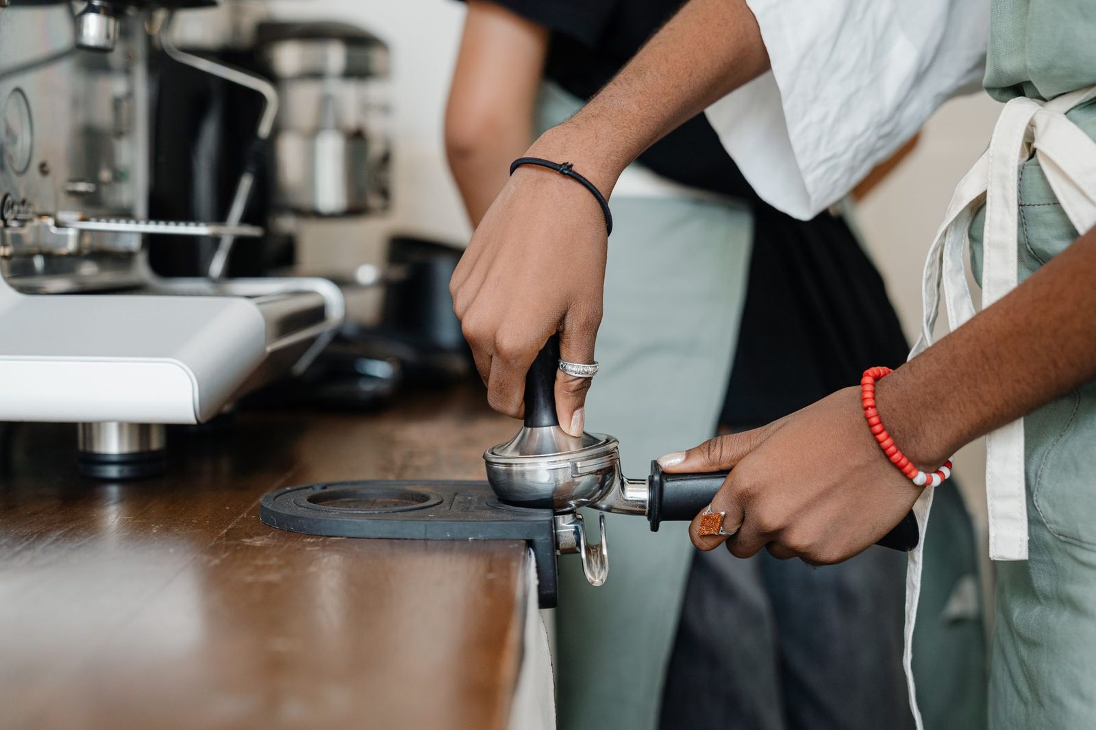 Barista distributing espresso grounds in a portafilter before tamping