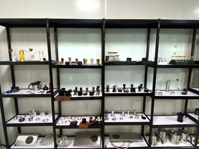 Sample room shelves displaying espresso tools and tampers